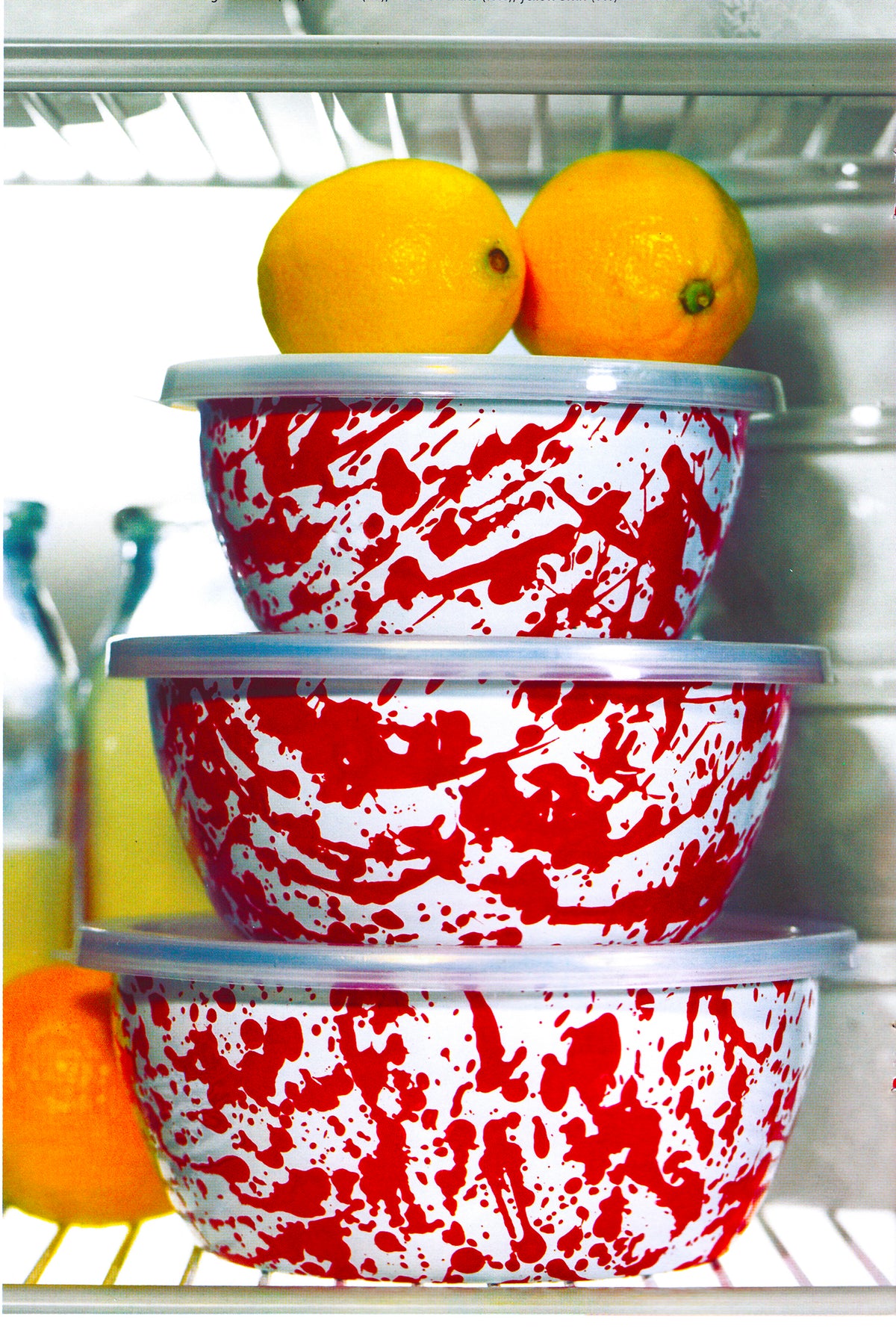 Front view of Nesting Bowls in Red Swirl showcasing three stacked bowls with removable lids in a refrigerator