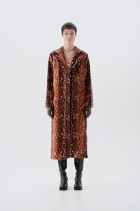 Model pictured from the back wearing a long brown faux fur coat with a bambi pattern