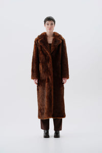 Model wearing a warm and long brown faux fur coat
