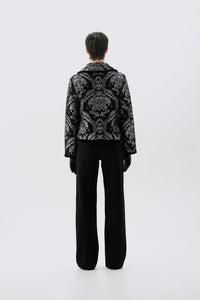 Black and silver patterned jacket, back view, paired with black pants