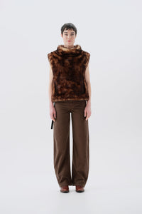 Model wearing a brown faux fur vest and pants on a white background