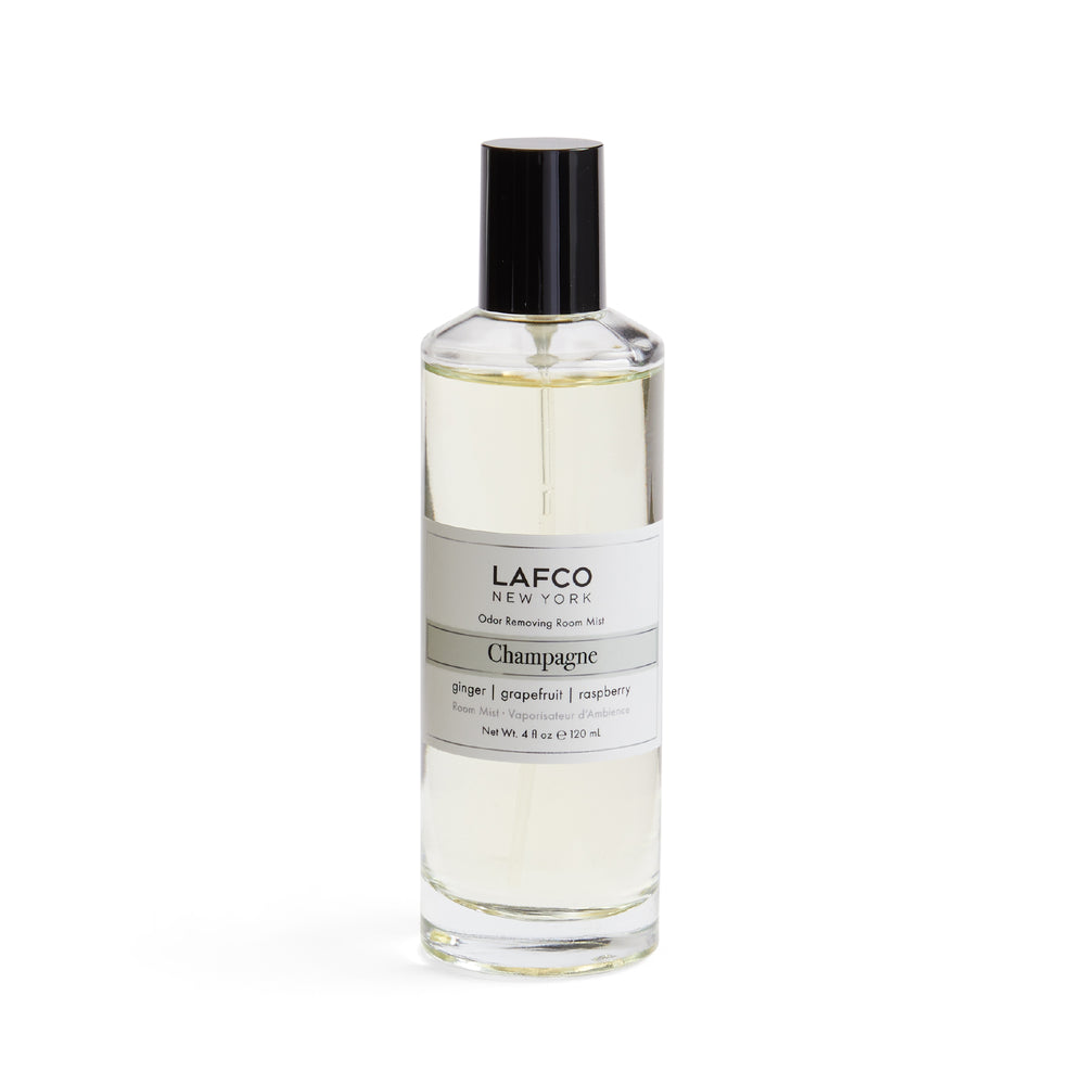 Front view of LAFCO Champagne odor-removing room mist bottle, clear glass with black cap and white label, 4 fl oz on white