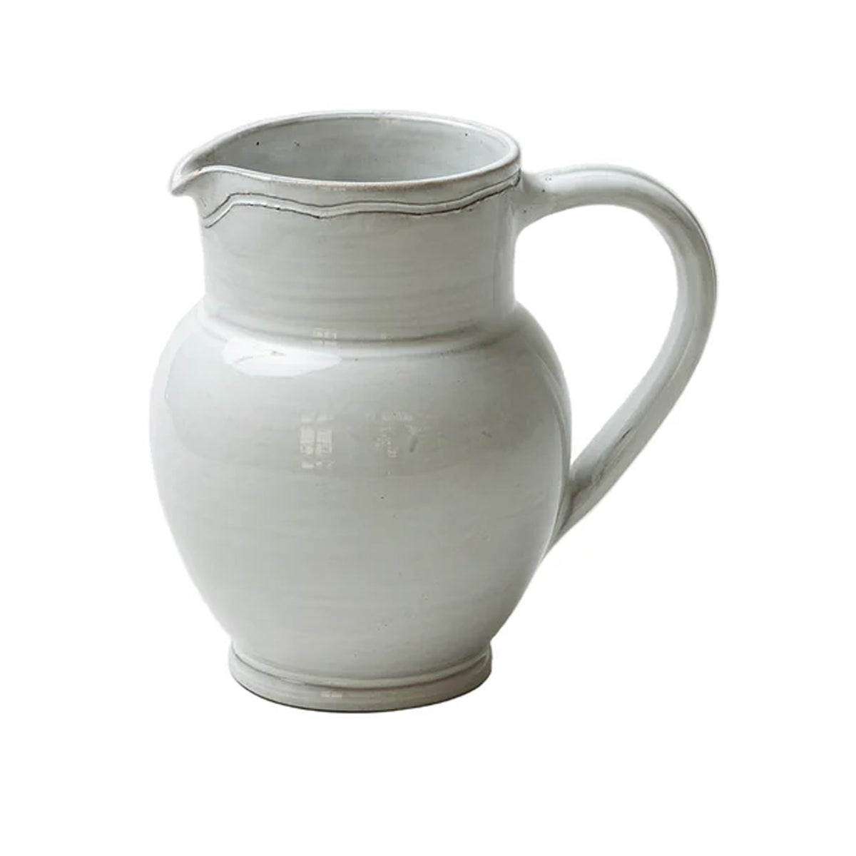 Three-quarter view of Radi Simple Pitcher showing rounded stoneware body, curved handle and spout, smooth off-white glaze