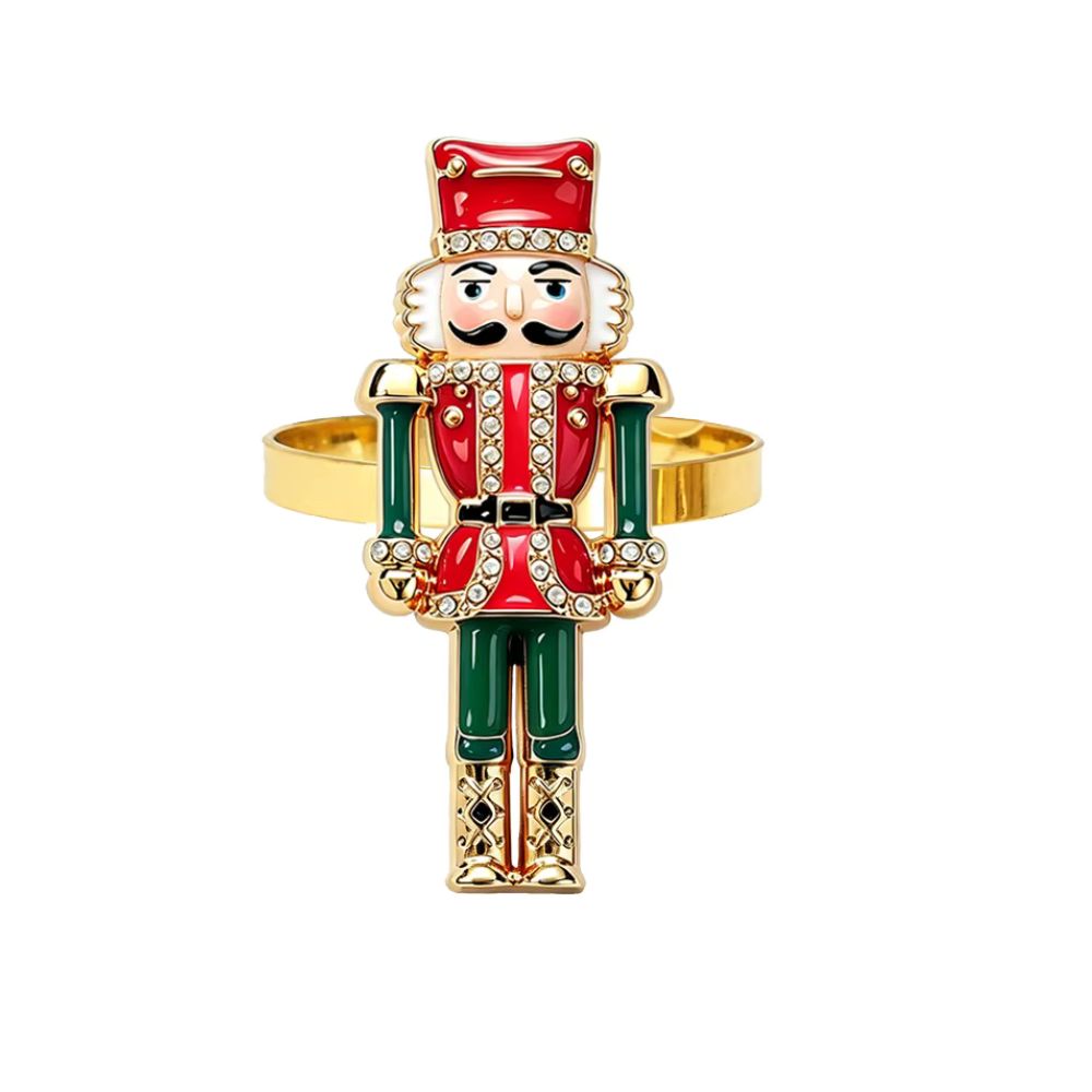 A gold-plated ring shaped like a nutcracker soldier, featuring red and green enamel details and rhinestone embellishments, set against a plain white background.