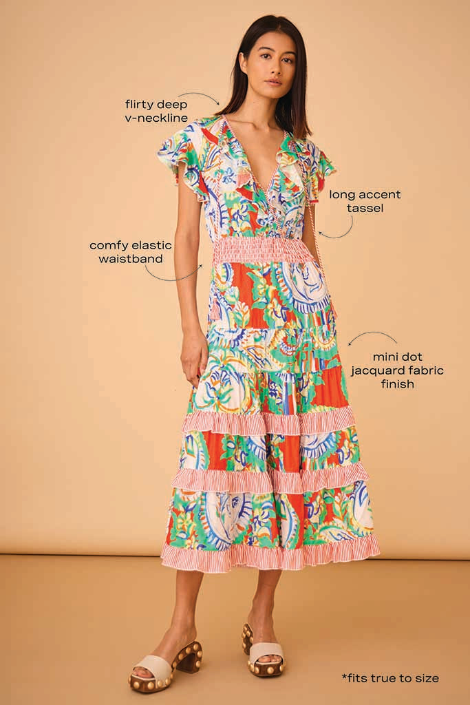 The Aurora Dress has a low-cut wrap ruffle neckline, rope ties, skirt ruffles, and a smocked waist.