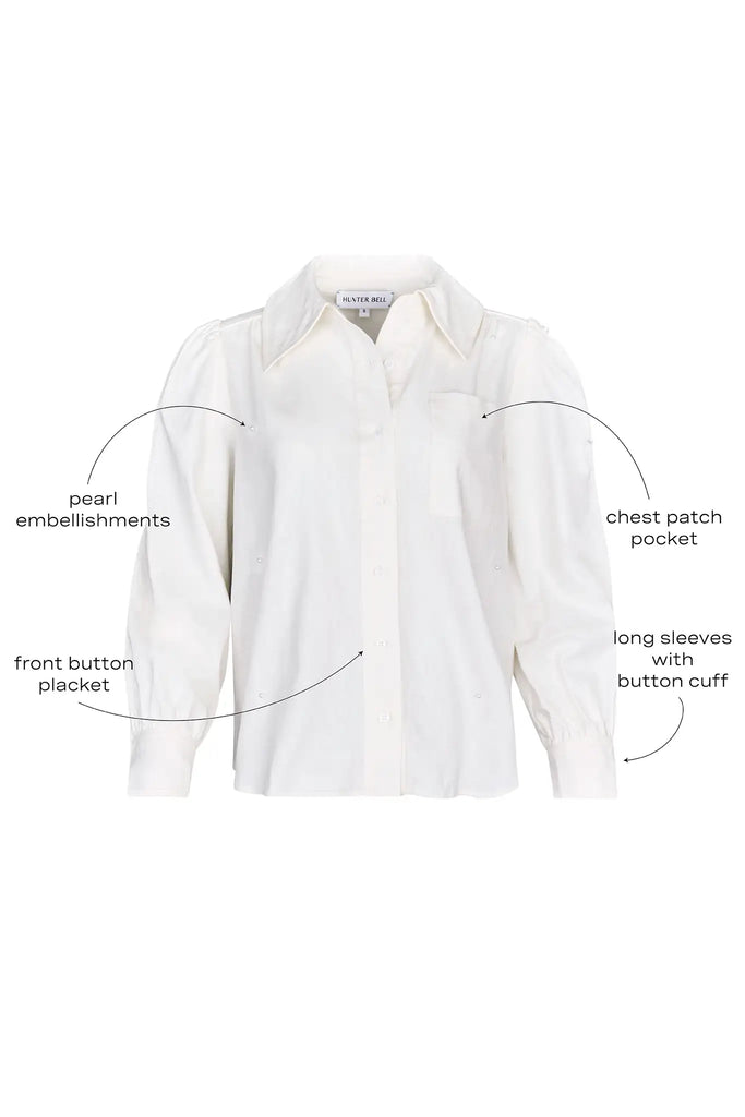 White linen long-sleeve collared shirt with roll-tab sleeves and pearl embellishments.