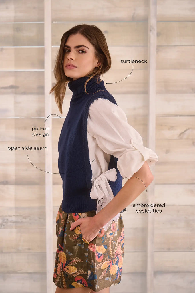 Navy wool blend turtleneck with an open side seam with embroidered eyelet ties.