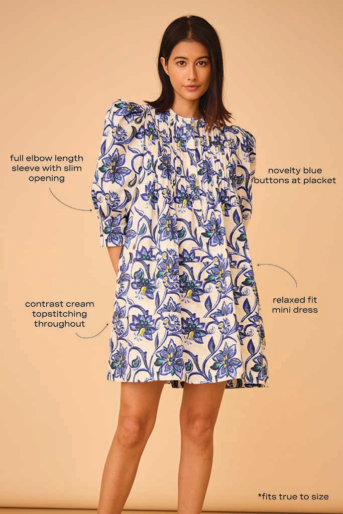 The Sidney dress has a crew neckline, ¾ length sleeves, pintucks on the bodice, and novelty buttons.