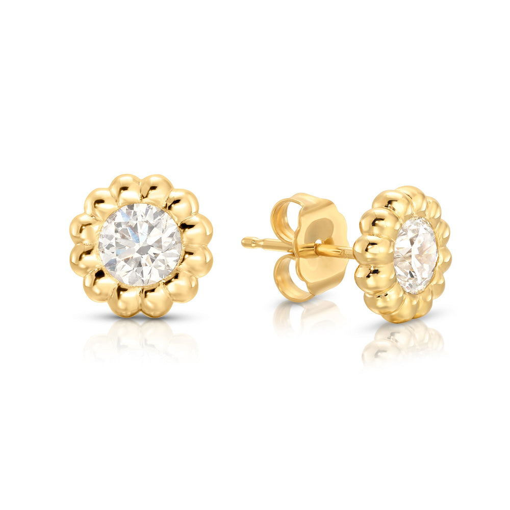 Front and side view of Reverie diamond stud earrings with 1 ct round diamonds in fluted 14K yellow gold bezels
