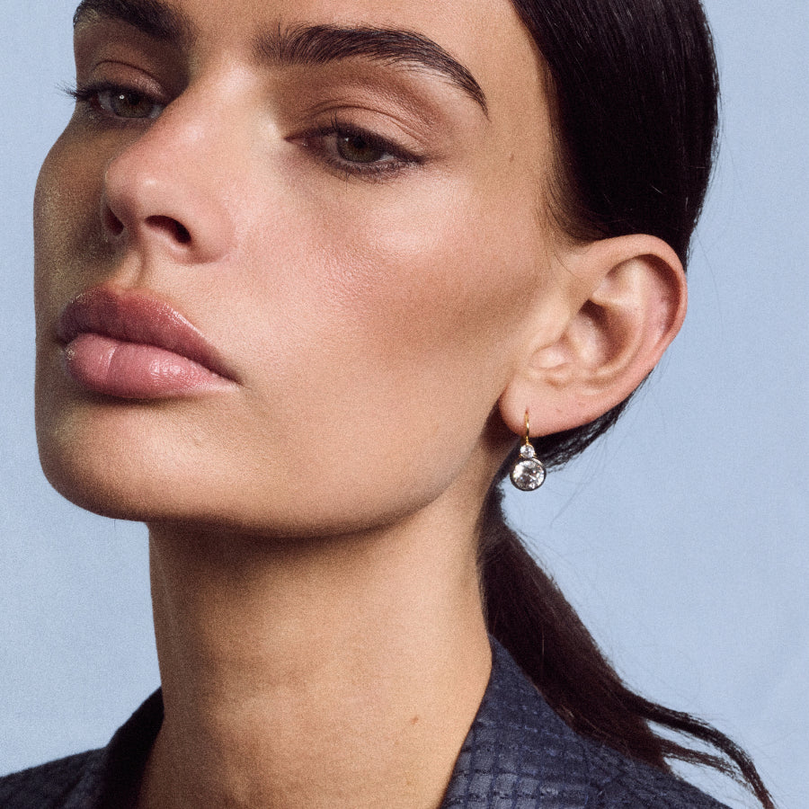 Close-up side view of Rhodium Double Bezel Drop Earrings showcasing the dangling double bezel design against a neutral background