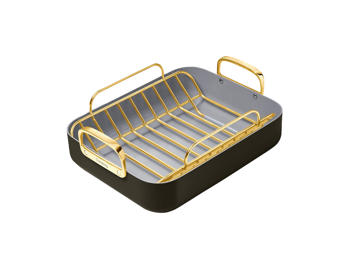 Three-quarter view of roasting pan with gold-tone rack showing light gray ceramic interior and dark exterior on white background