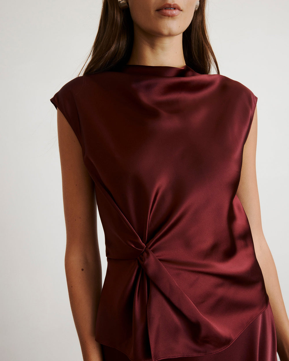 Front close up of Robin Top in mahogany showing satin sheen, side knot detail and cap sleeves on neutral background