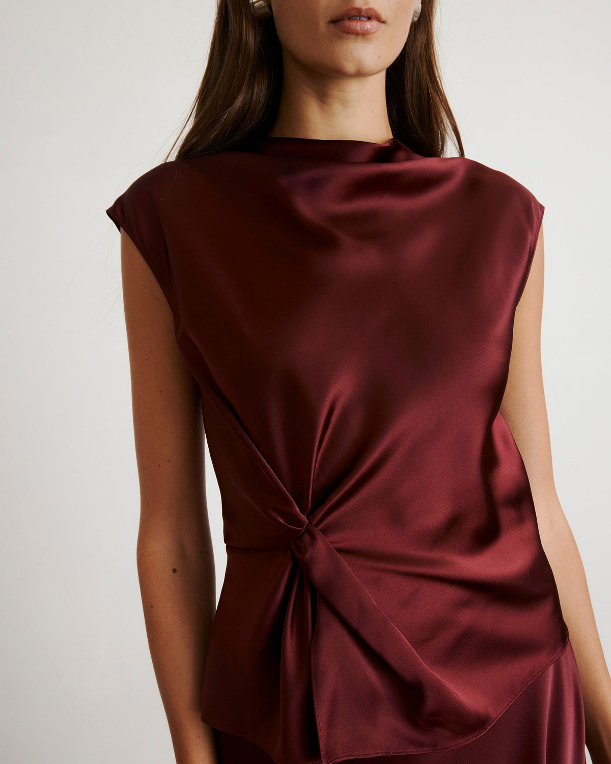 Front close up of Robin Top in mahogany showing satin sheen, side knot detail and cap sleeves on neutral background