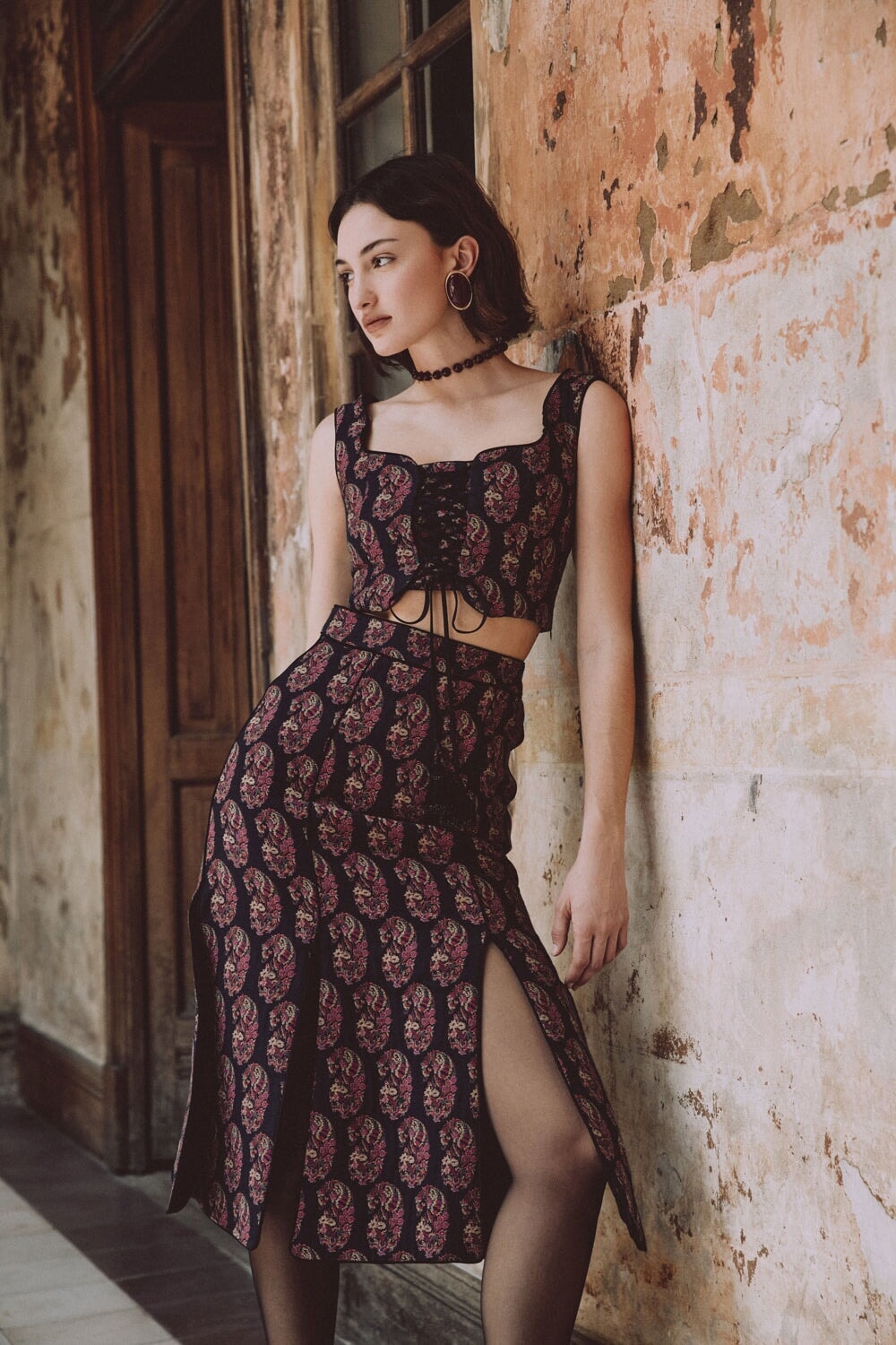 Front of Shalimar Bustier in burgundy Termeh showing lace-up front and paisley embroidery, fitted on model in aged interior