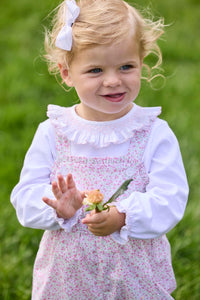 Little English traditional children's clothing.  Light pink and green floral overall with ruffle detailing layered over white knit smocked Madeline Blouse in light pink