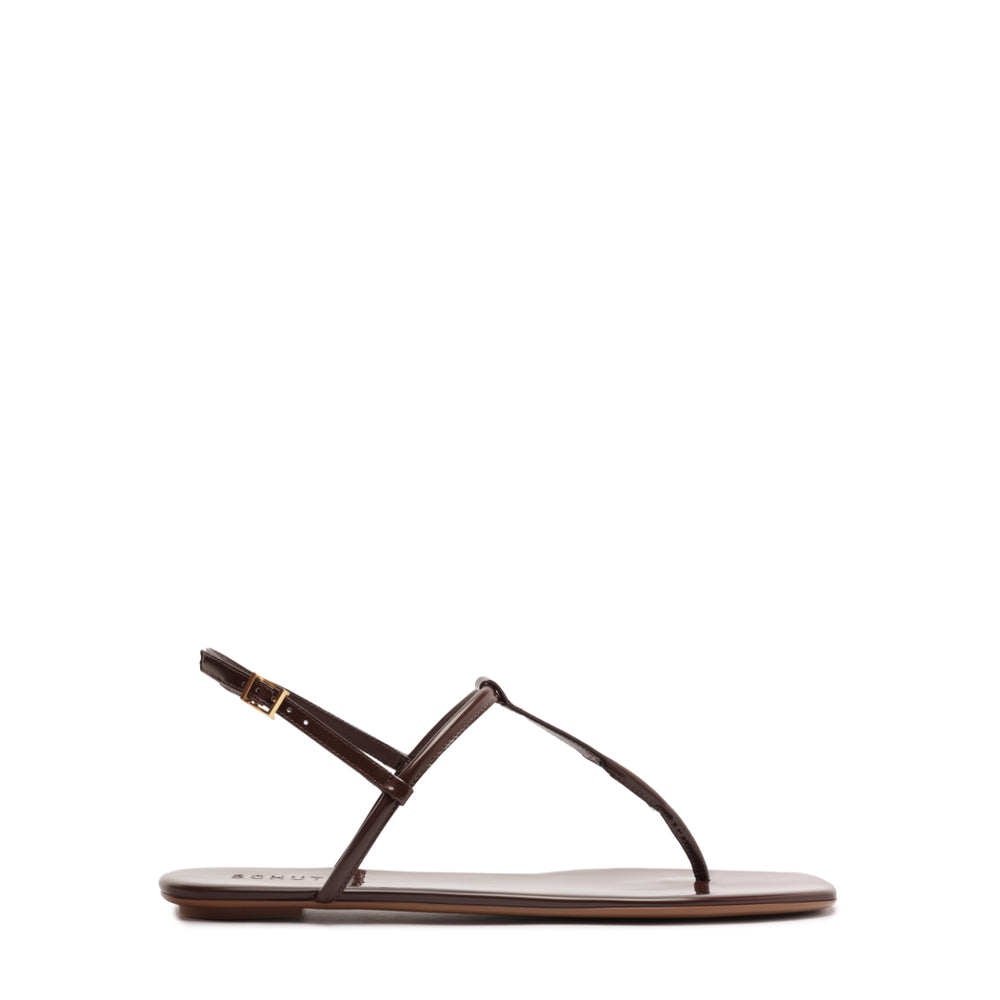 Side view of Elsha sandal in root brown showcasing delicate T-strap, ankle buckle, and flat sole on white background