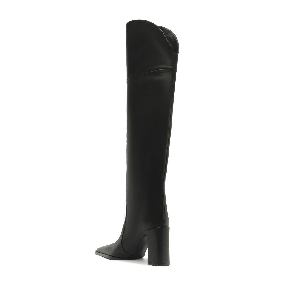 Side view of black over-the-knee leather boot showcasing pointed toe and block heel with white background