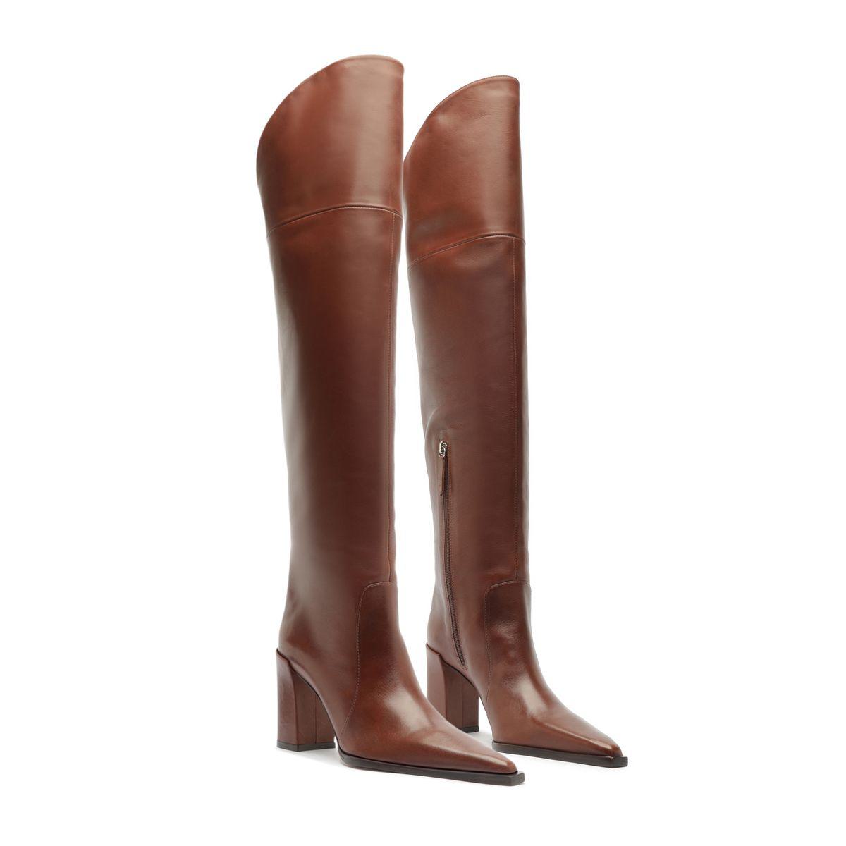 Three-quarter view of Raffaela over-the-knee leather boots in warm toffee showcasing tall shafts and pointed toes against a white background