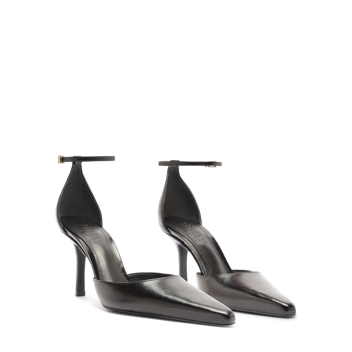 Three-quarter view of Jenny Leather Pump in Black showcasing pointed toes, buckle details, and stiletto heels on white background