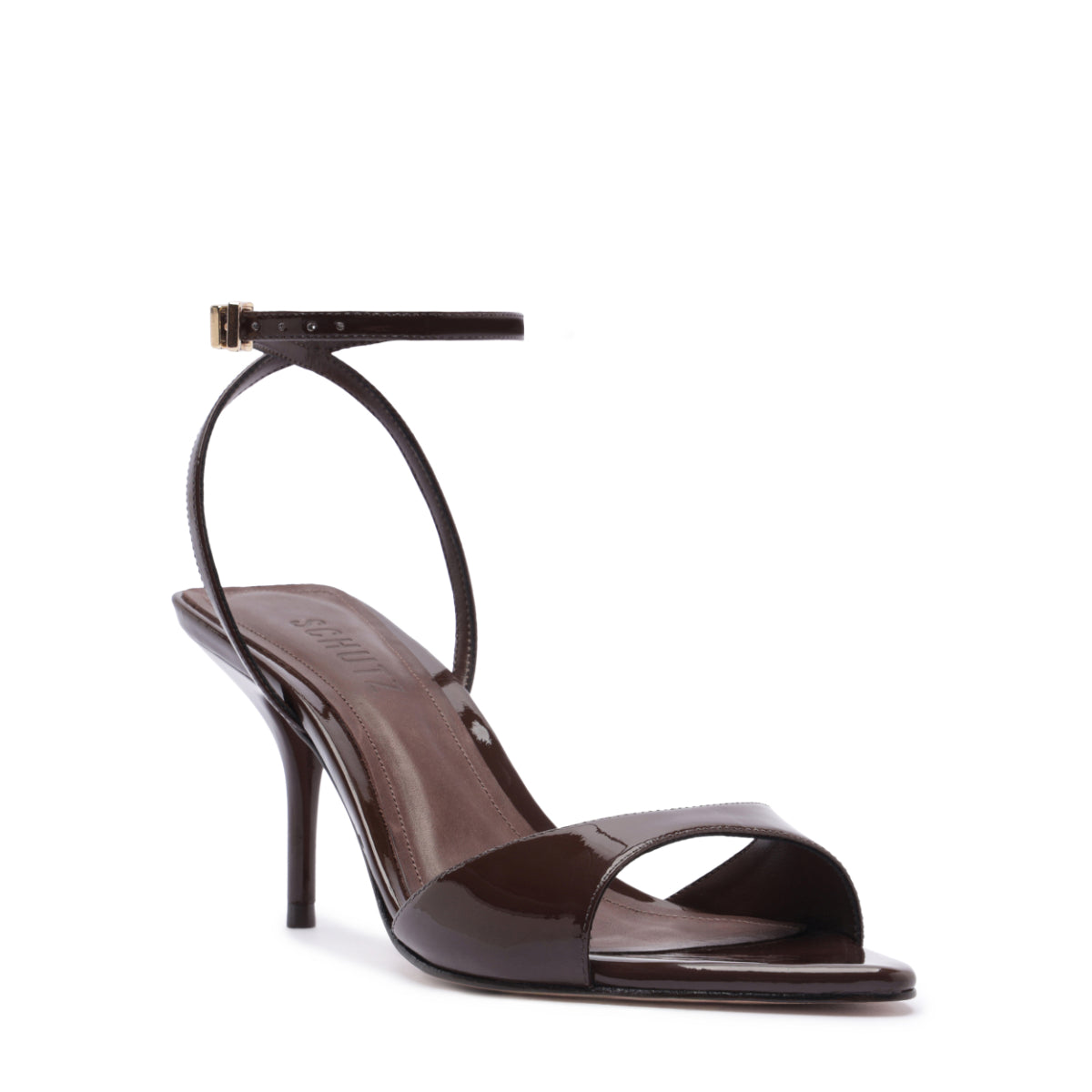Three-quarter view of Elodie Buckle sandal in root brown with patent leather open toe, ankle buckle and mid-stiletto heel