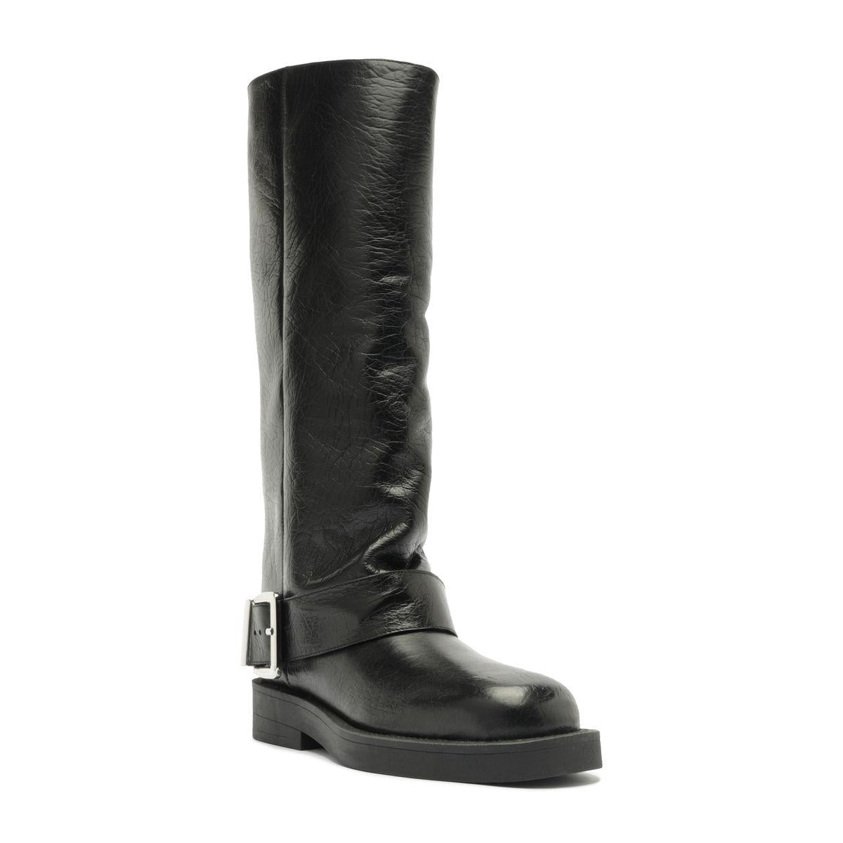 Three-quarter view of Patrice Up Boot in Black showcasing its tall ruched shaft, buckle strap, and lug sole on a white background