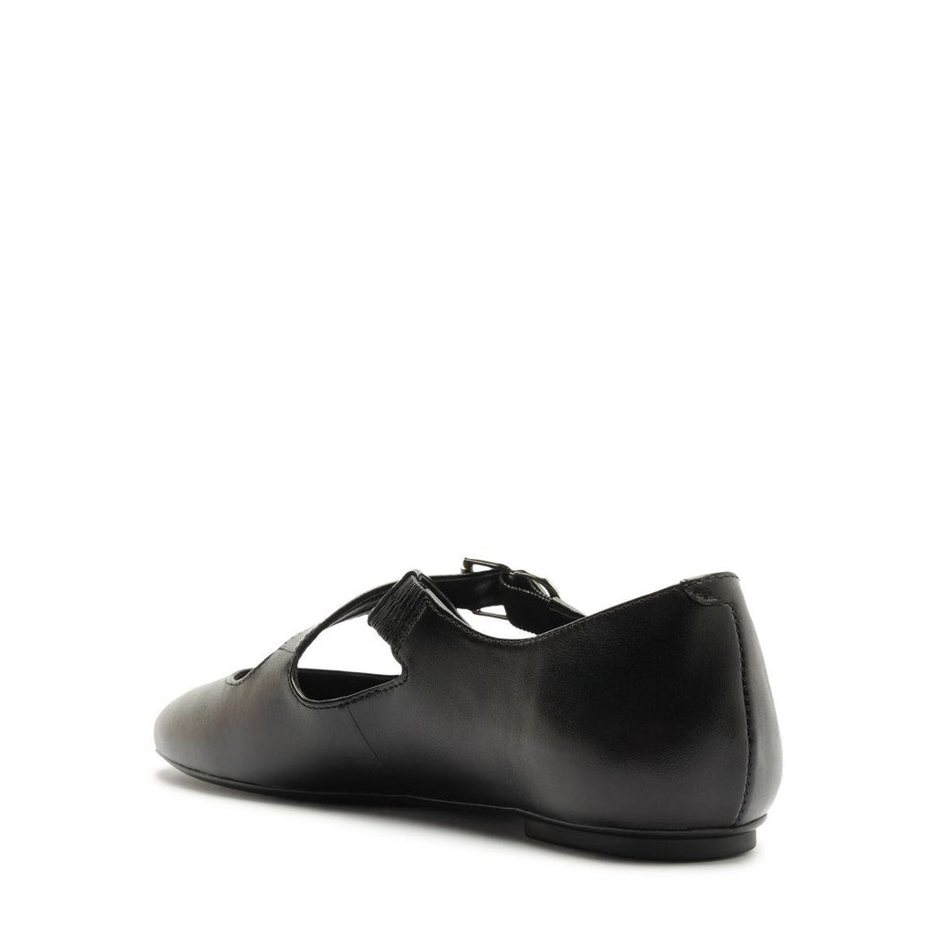 Side view of Molly Flat in Black showcasing its buckle strap, round toe, and closed counter against a white background