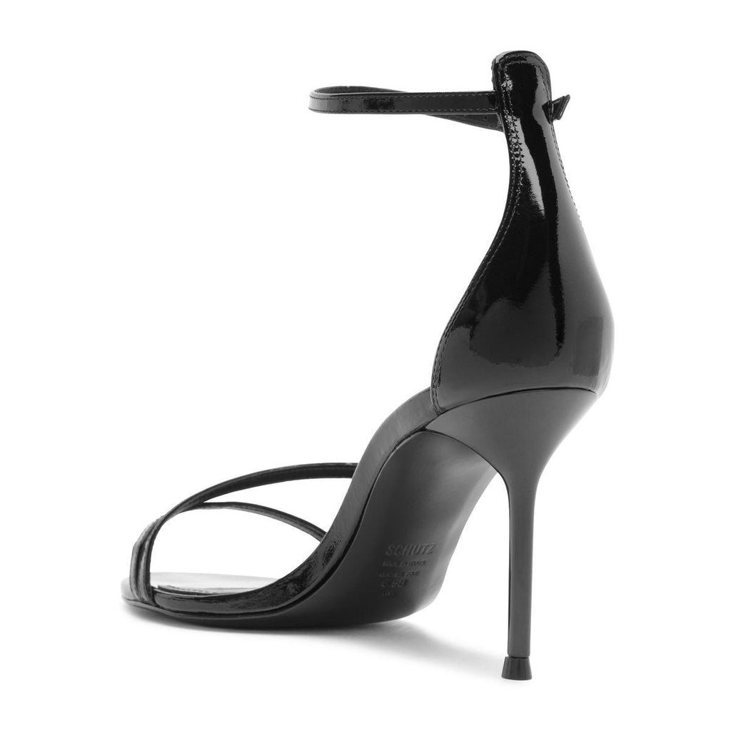Side view of the Tessa Patent Sandal in Black showcasing glossy patent straps and stiletto heel with a white background
