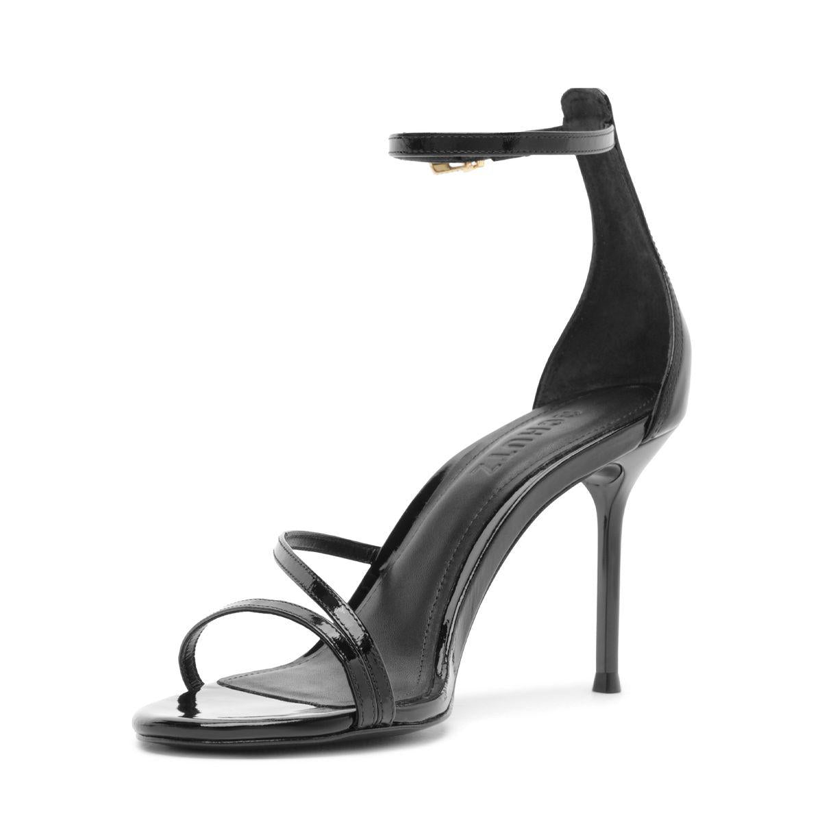 Side view of Schutz Tessa Patent Sandal in Black showcasing glossy straps, stiletto heel, and round toe on a white background