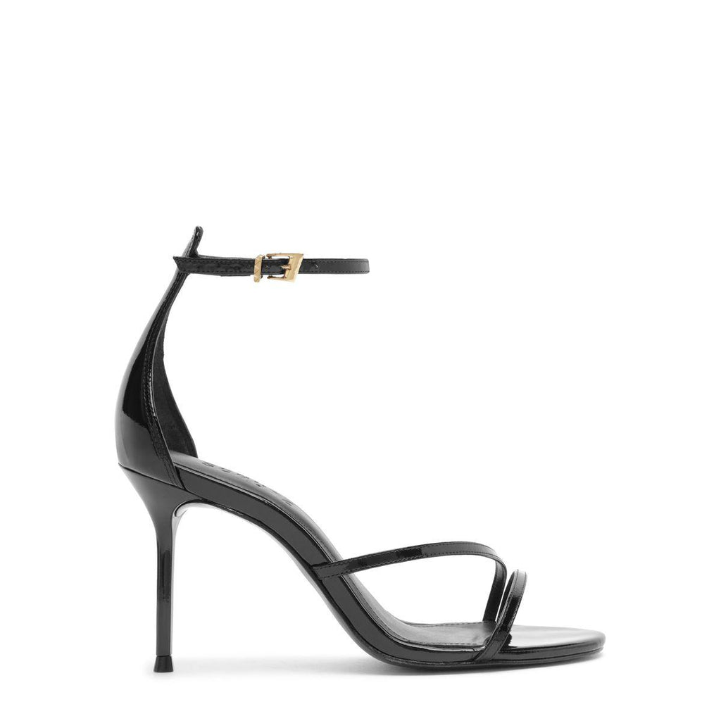 Side view of the Tessa patent sandal in black showcasing glossy patent leather straps and high stiletto heel on white background
