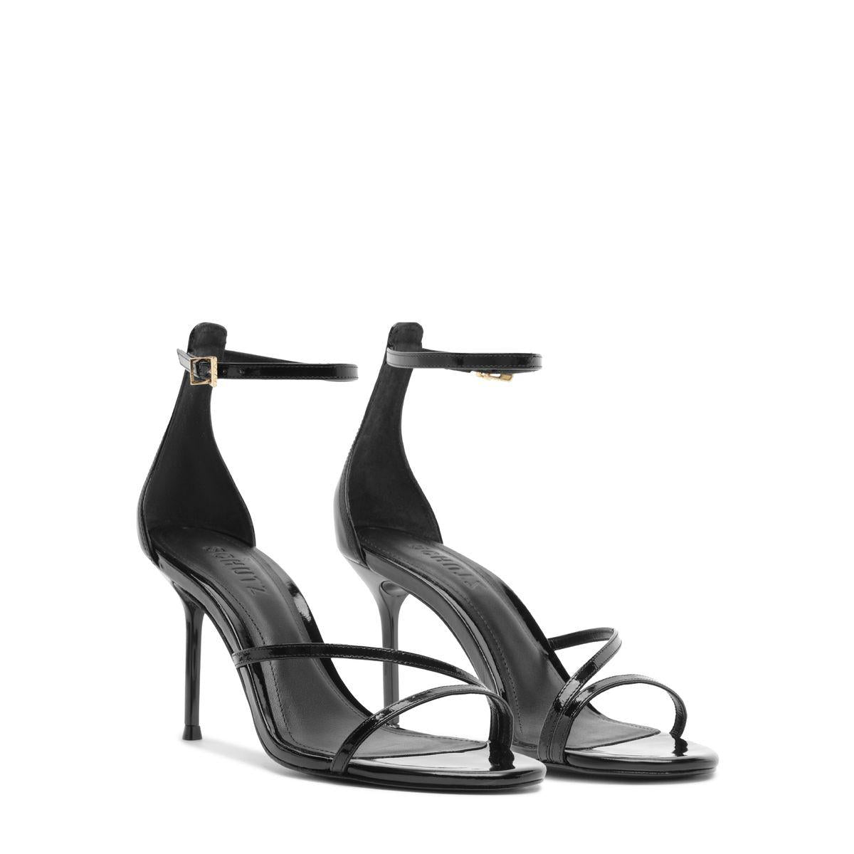 Three-quarter view of Tessa Patent Sandal in Black showcasing glossy straps and stiletto heels on a white background