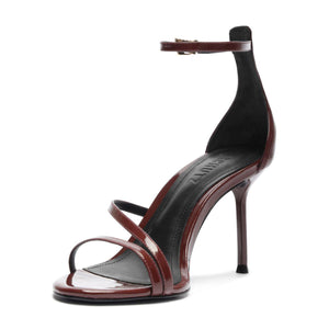 Three quarter view of Tessa Patent Sandal in Port Burgundy showcasing glossy patent leather straps and stiletto heel with a white background