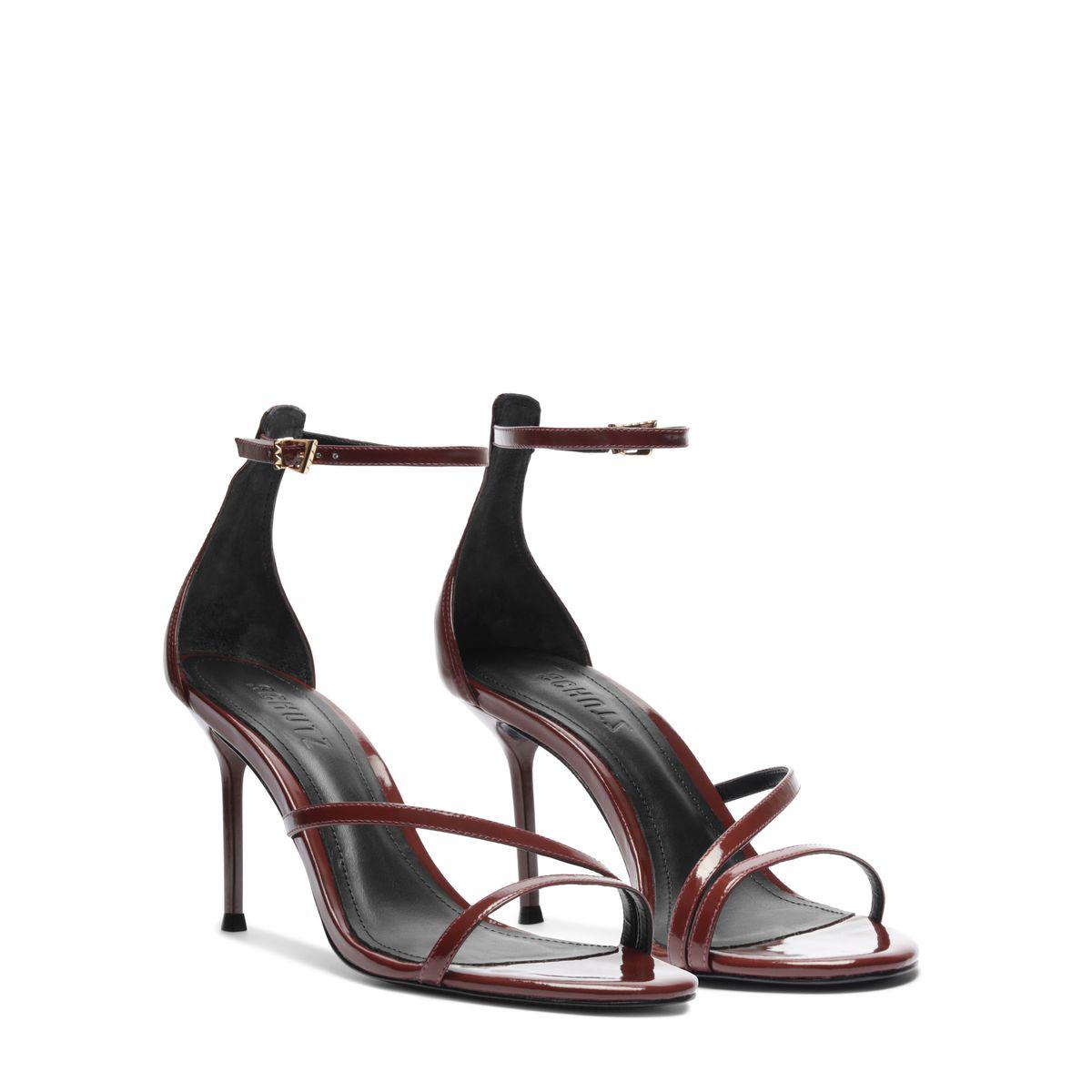 Angled view of Tessa Patent Sandal in Port Burgundy showcasing glossy patent straps and stiletto heels on a white background