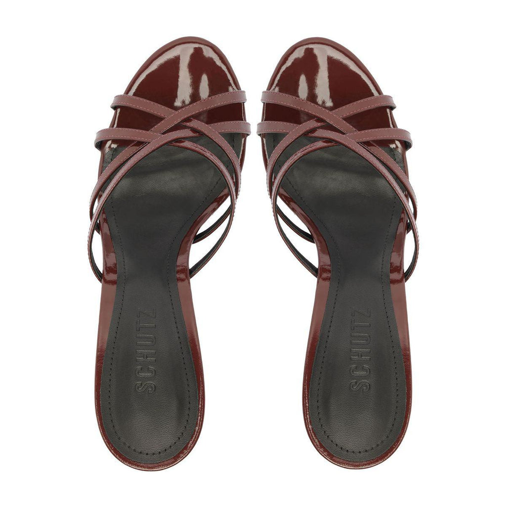 Top view of Marion Patent Sandal in Port Burgundy showcasing crisscross patent straps and dark footbeds on a white background