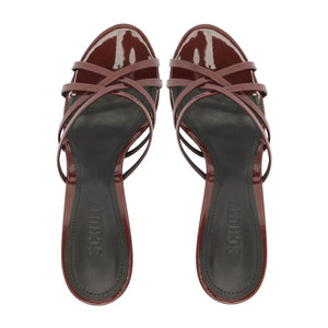 Top view of Marion Patent Sandal in Port Burgundy showcasing crisscross patent straps and dark footbeds on a white background