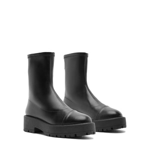 Three-quarter view of Rita Bootie in Black showcasing round toes and lug soles against a white background