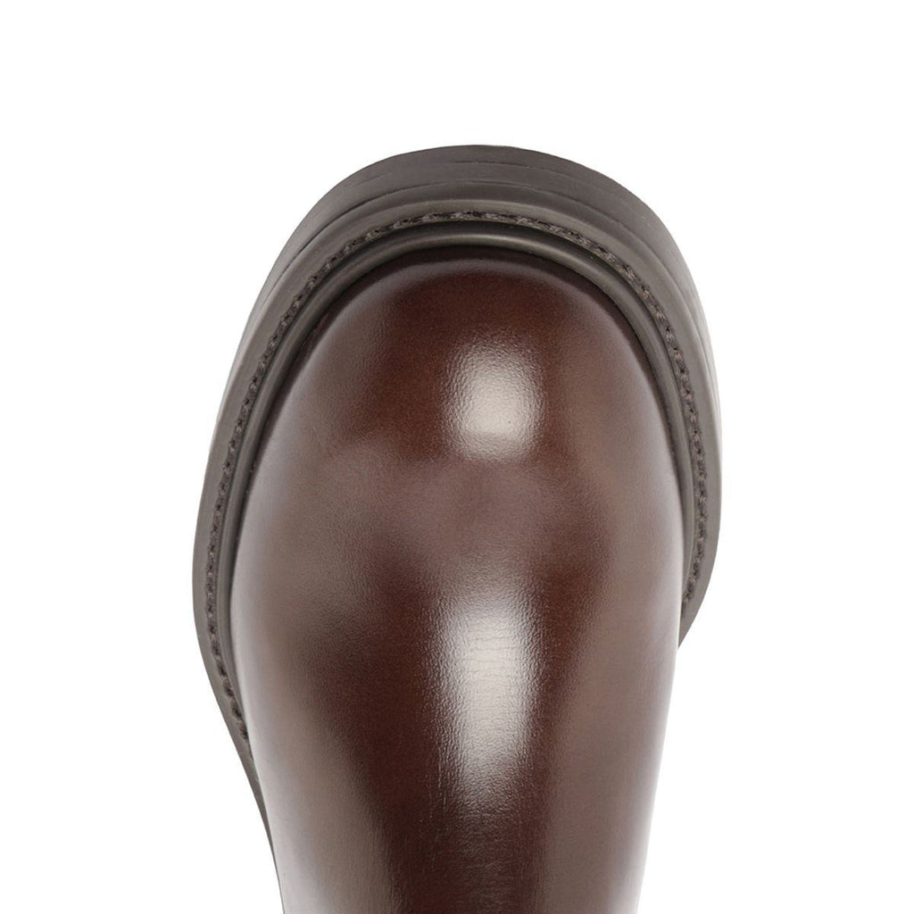 Close-up view of Olivia Bootie in Root Brown showcasing its glossy brown toe with a white background