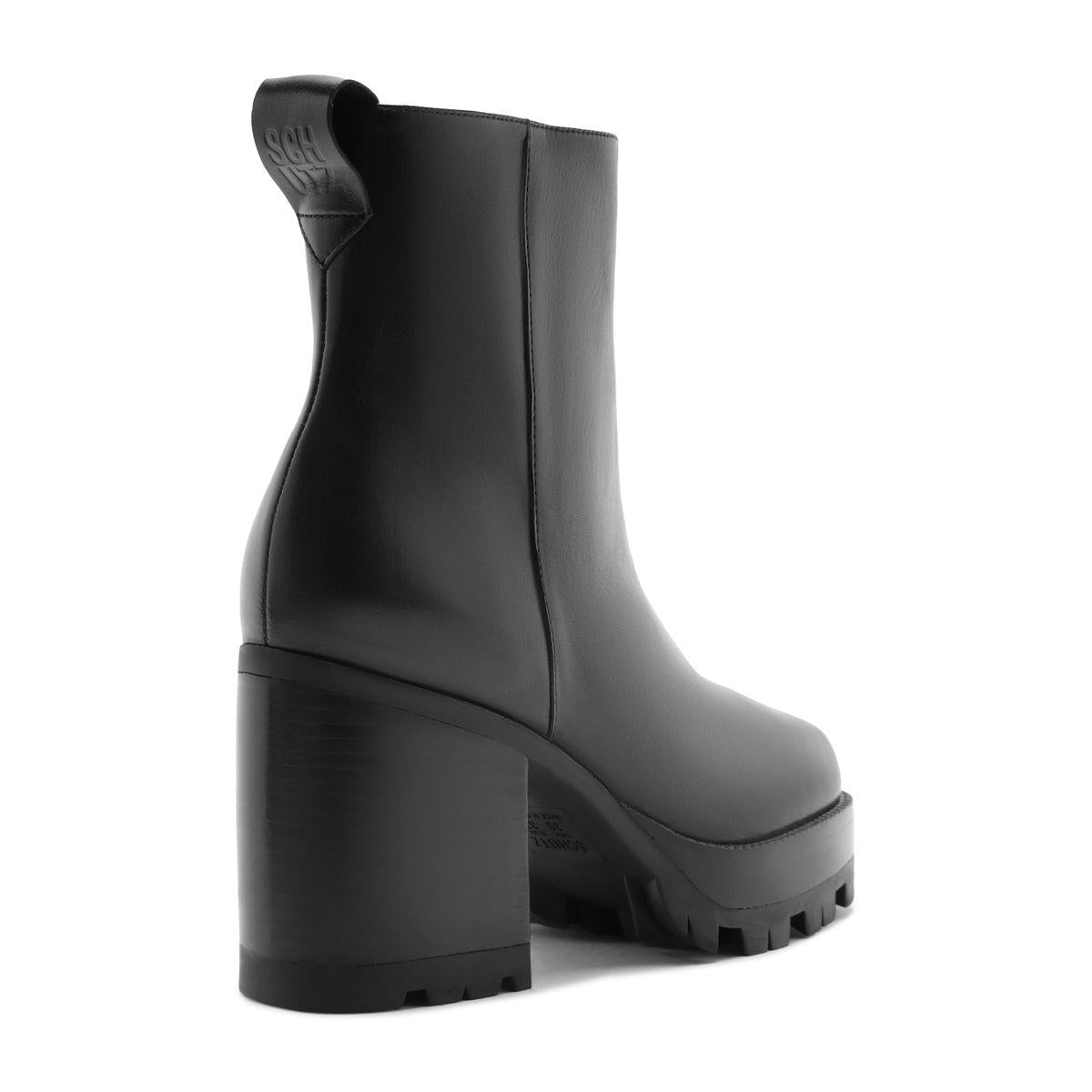 Rear three-quarter view of 240 Leather Bootie in Black showcasing a block heel and lug sole on a white background