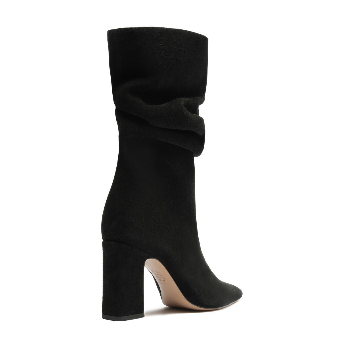 Side view of Harriet suede boot in black showcasing a draped shaft, block heel, and pointed toe on a white background