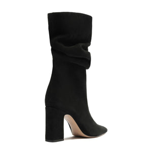 Side view of Harriet suede boot in black showcasing a draped shaft, block heel, and pointed toe on a white background