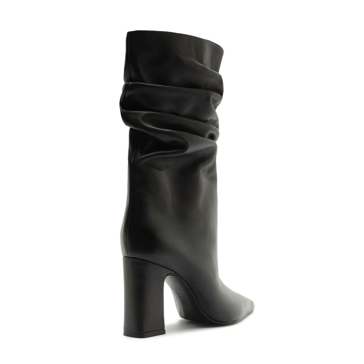 Side view of Harriet leather boot in black showcasing a ruched shaft and block heel on a white background