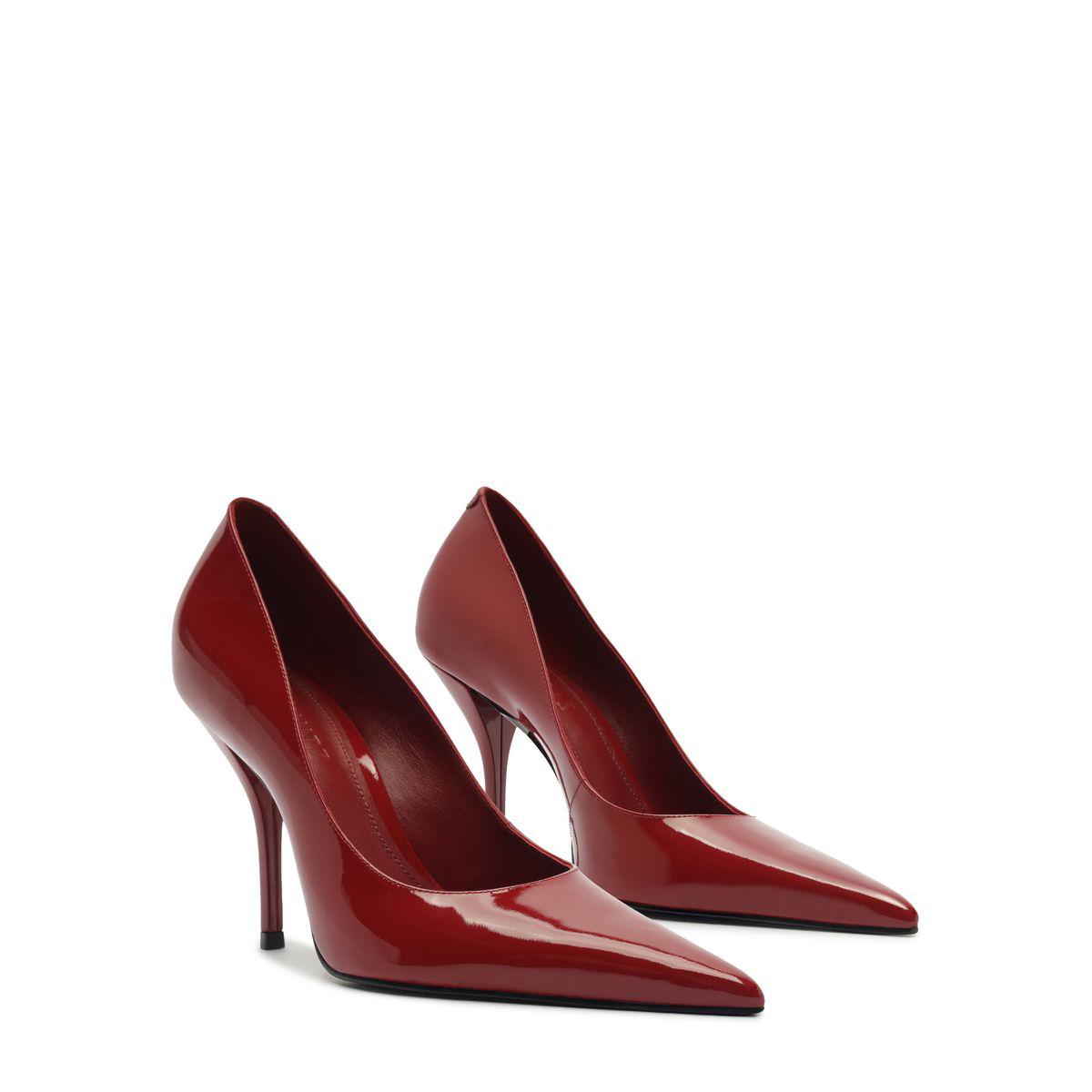 Side view of Miranda patent pumps in passion red showcasing pointed toes and stiletto heels on a white background