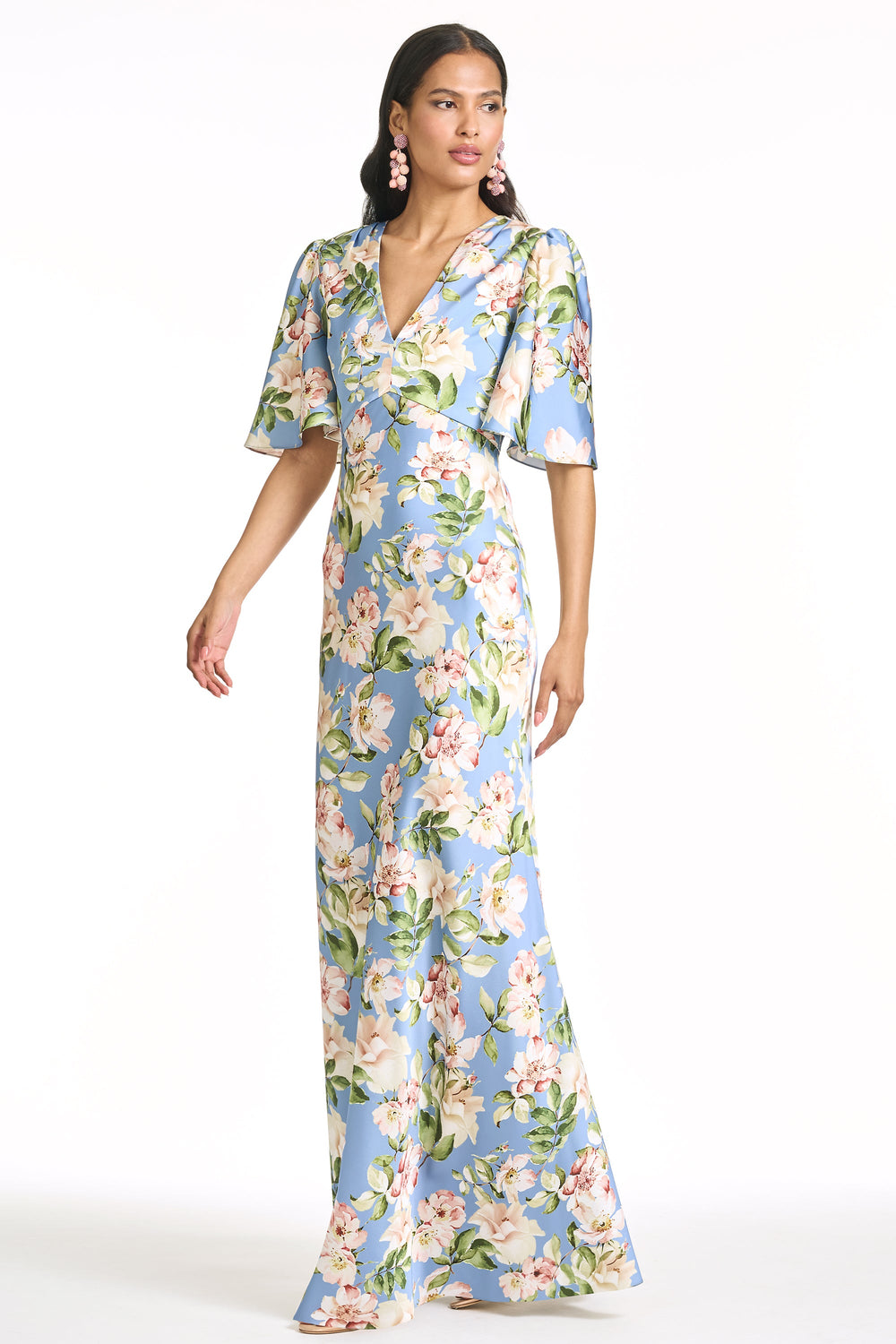 Three-quarter view of Mae gown in Twilight Camellias with V-neckline, flutter sleeves, A-line silhouette on white background