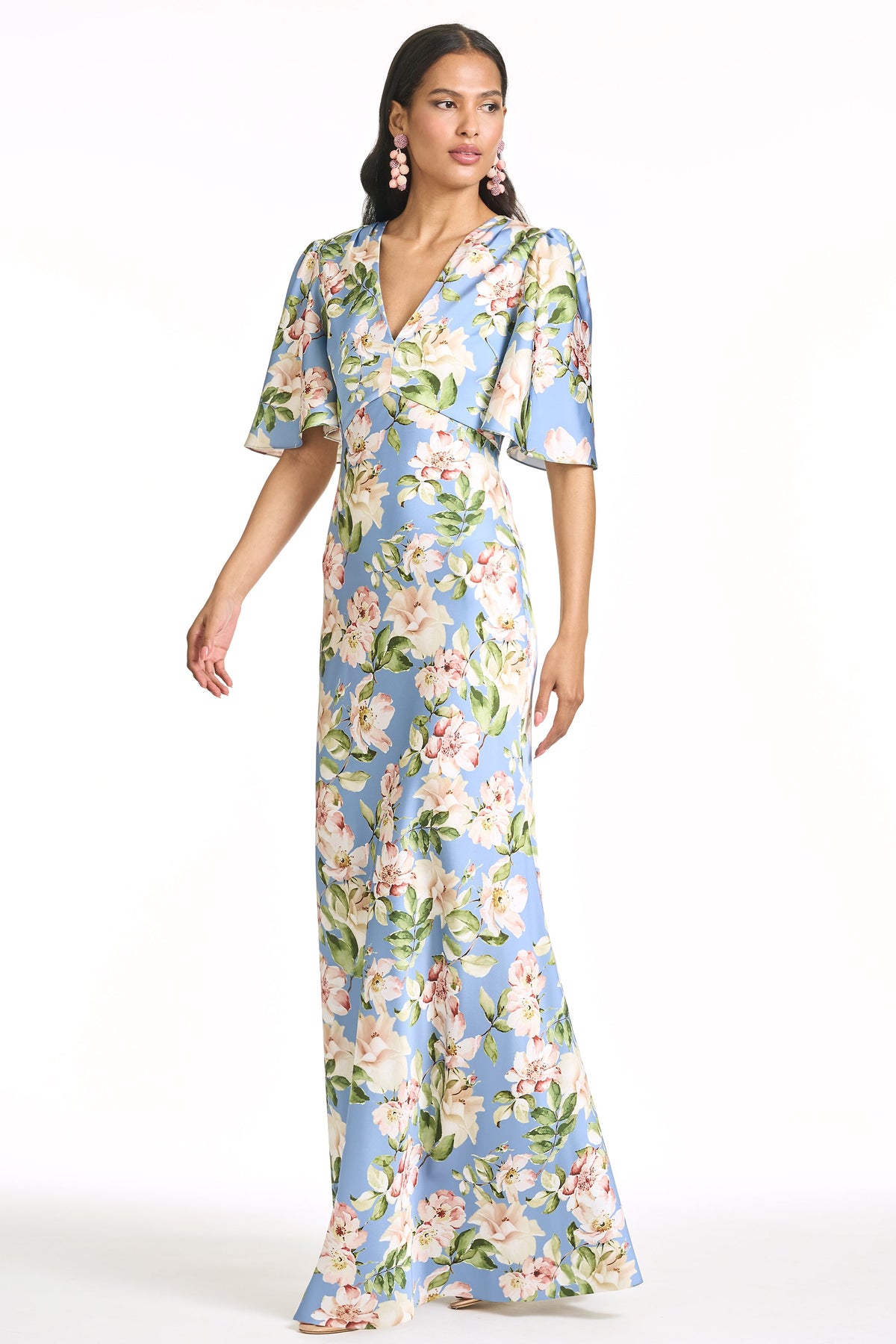 Three-quarter view of Mae gown in Twilight Camellias with V-neckline, flutter sleeves, A-line silhouette on white background