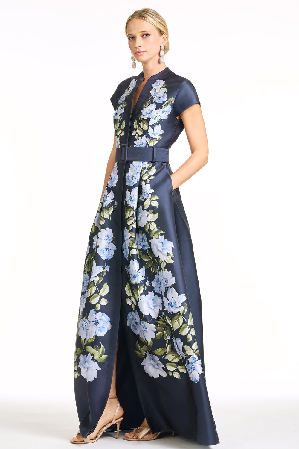 Three-quarter view of Marta Gown in Floral Fresco showcasing belted mikado fabric, blue floral print, short sleeves and front slit on white background