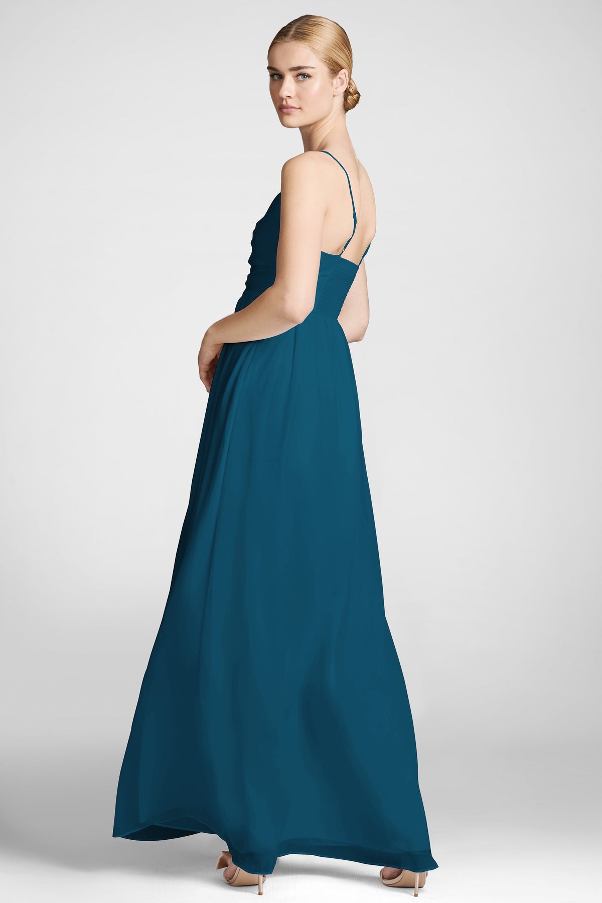 Side view of Sienna Gown in Bottle Green showcasing its open back and adjustable straps on a model against a light gray background