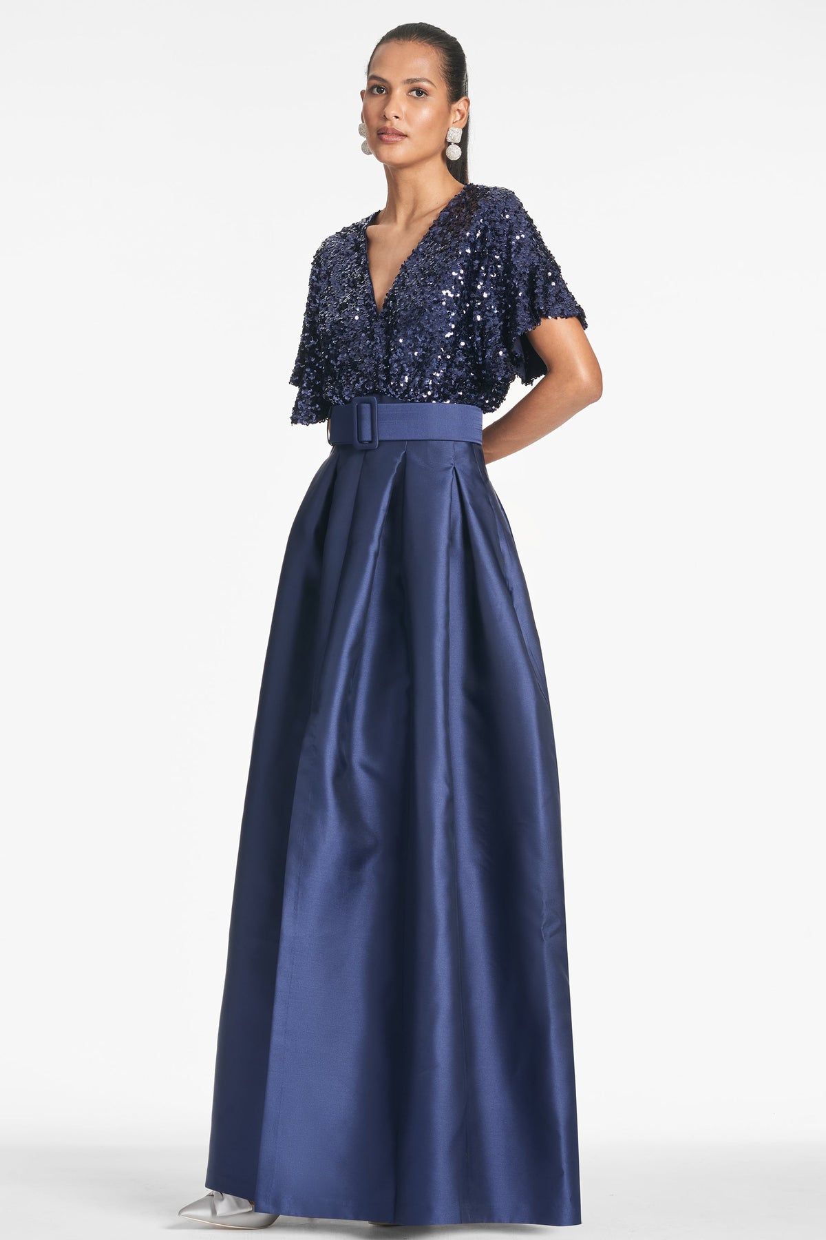 Three-quarter view of Simone Gown in Night Sky showcasing sequined drop sleeves, self-belt, and pleated Mikado ball skirt against a white background