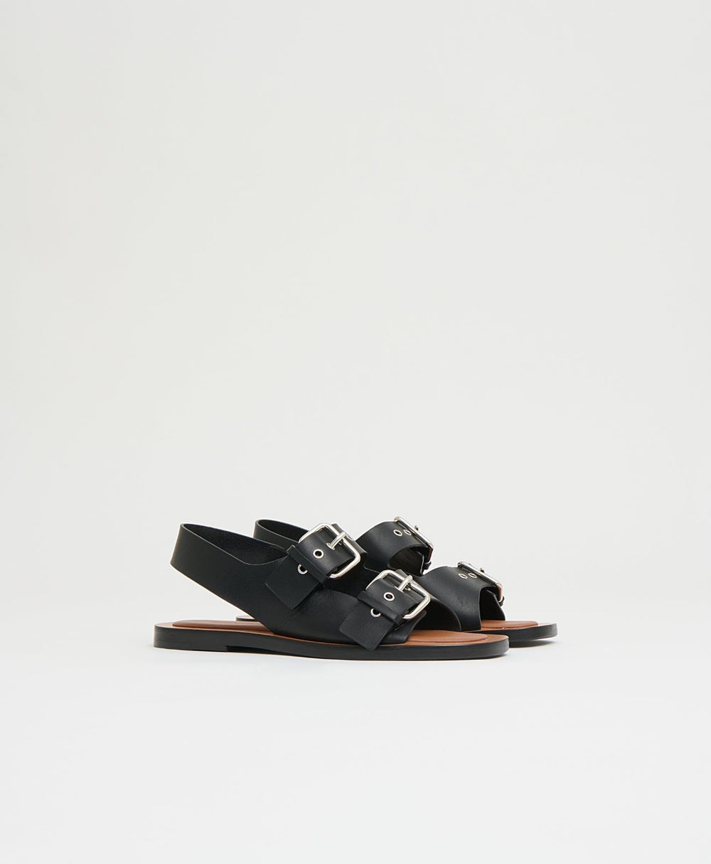 Side view of Cintura sandal in black showcasing two adjustable buckle straps, slingback and flat padded sole on white background