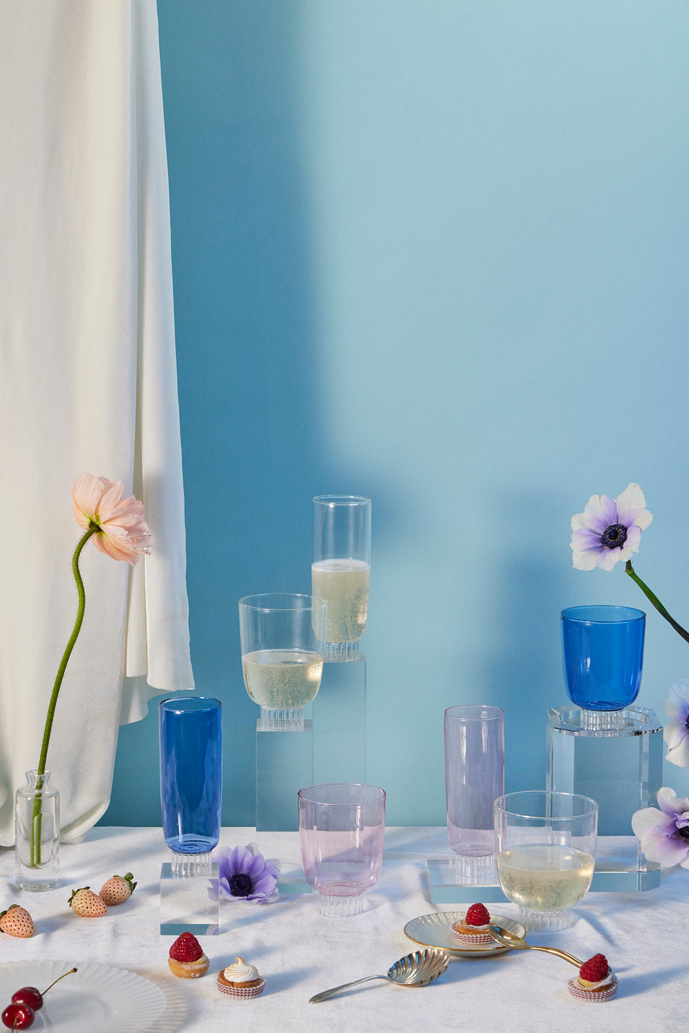 Group front view of Grande Romantic stemless glasses set of 4 showing ribbed bases and pastel blue and pink tones on a styled tabletop