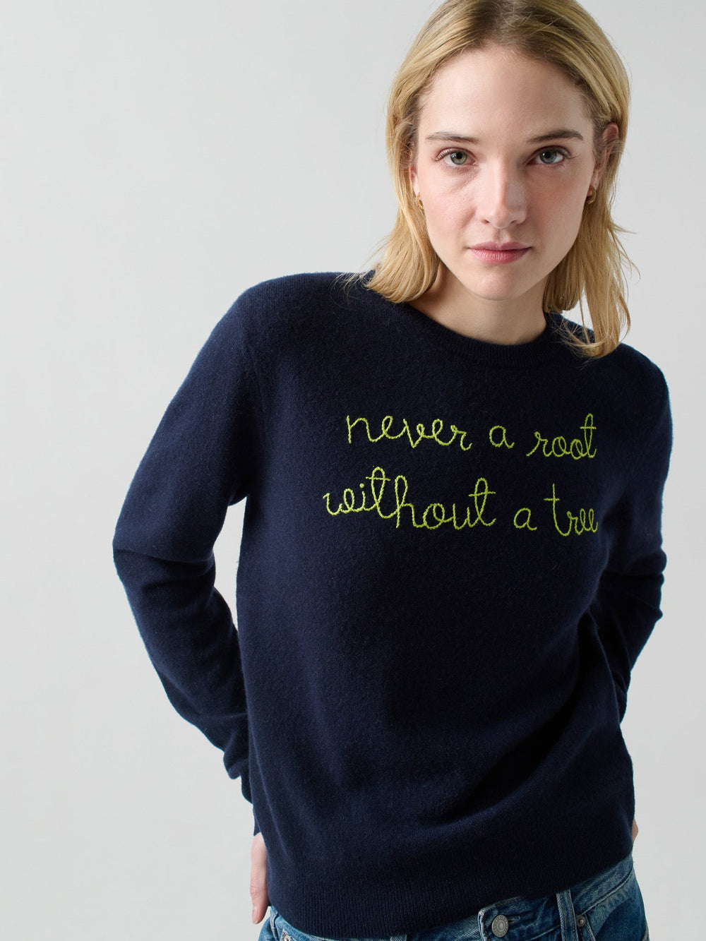 Front view of Never a Root crewneck with neon-green embroidered text never a root without a tree on light gray background