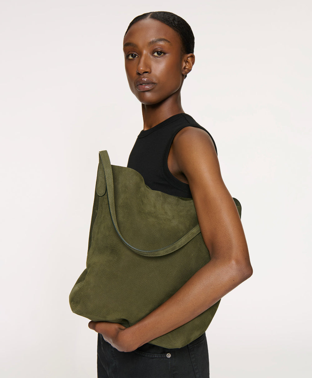 Side view of Everyday Cabas in algae showcasing slouchy nubuck leather and elongated handles against a plain light background